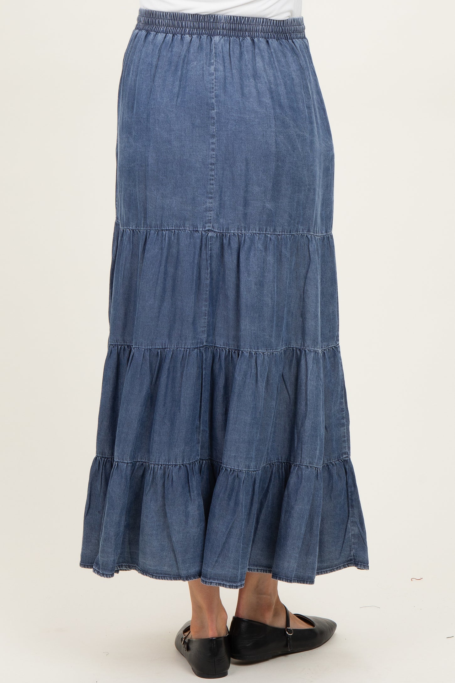 maternity wear dark denim tiered maxi skirt with an elastic waistband worn by a model from the back