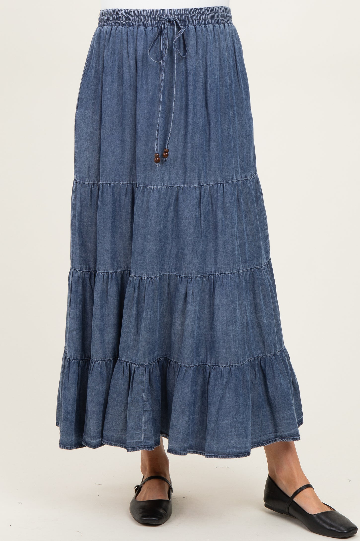 woman wearing a blue tiered denim maternity skirt with an elastic waistband and drawstring