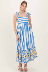 woman wearing a blue and white striped maxi dress with tie straps and floral print at the hem