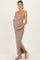 woman wearing a beige and brown striped maternity maxi dress with a side slit and holding her baby bump