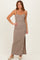 woman wearing a brown and beige striped maxi dress with a side slit and thin straps