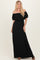 woman wearing a black off-the-shoulder maxi dress with ruffled sleeves and a fitted waistline