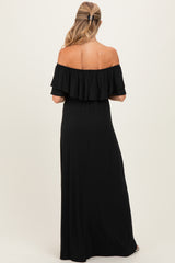 woman wearing a black off-the-shoulder maternity maxi dress, showing the ruffled neckline from the back