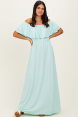 woman wearing a mint green off-shoulder maxi dress with ruffle detailing and a cinched waist