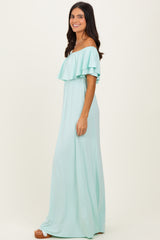 woman wearing a light mint green off-the-shoulder maxi dress with ruffled layers and a fitted waist
