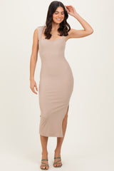 woman wearing a beige ribbed midi dress with a scoop neckline and side slit
