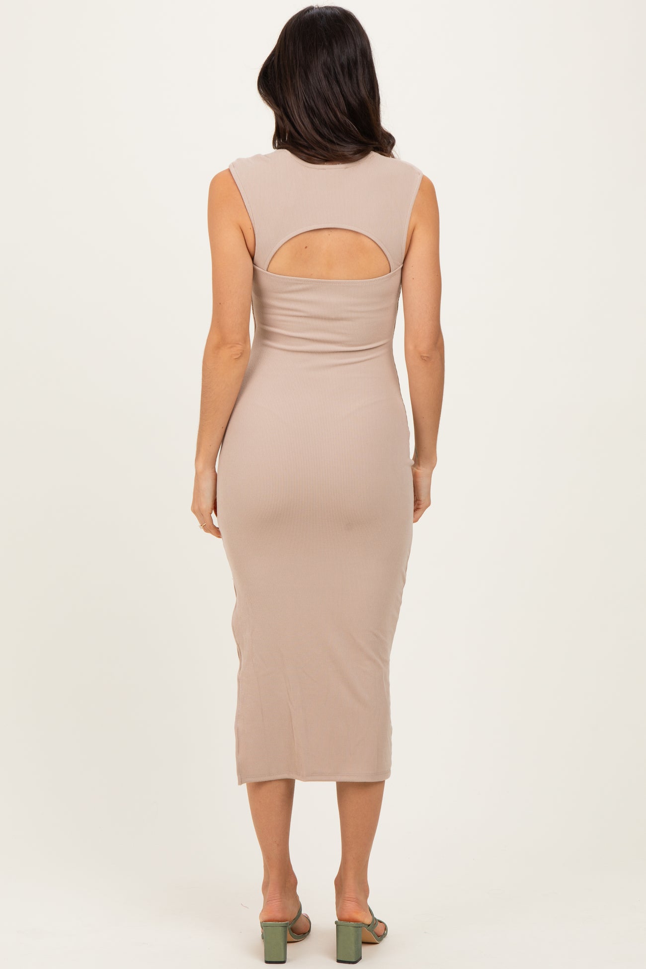 woman wearing a beige ribbed midi dress with a back cutout and a fitted silhouette