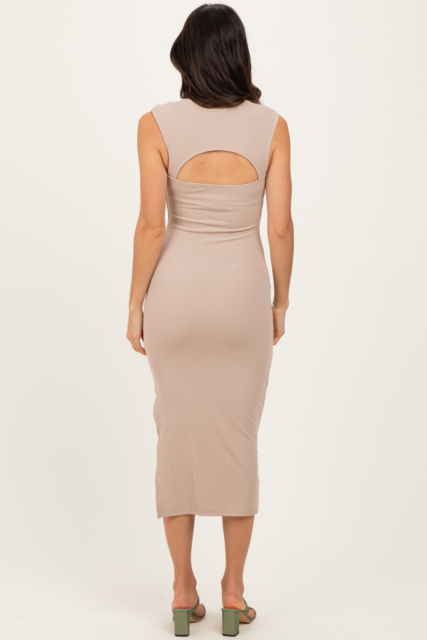 woman wearing a beige ribbed midi dress with a back cutout and a fitted silhouette
