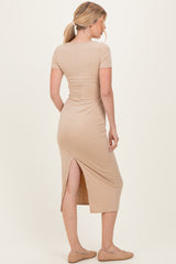 woman wearing a beige ribbed midi dress with a back slit and short sleeves