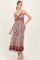 woman wearing a floral maxi dress with a fitted bodice and spaghetti straps, styled with a flowing skirt