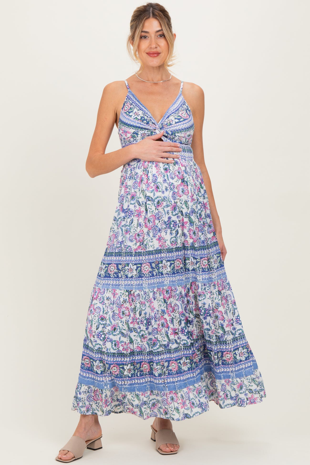 woman wearing a floral print maternity maxi dress and holding her baby bump
