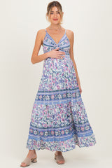 woman wearing a floral print maternity maxi dress and holding her baby bump