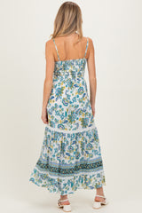 woman wearing a floral maxi maternity dress with a tiered skirt and adjustable spaghetti straps