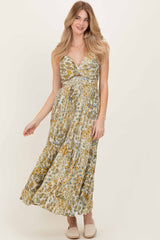 woman wearing a floral print maxi dress with a deep v-neck and braided straps, posing with a smile