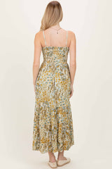woman wearing a floral print maxi dress with a smocked bodice and tiered skirt, showing the back view