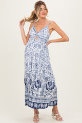 woman wearing a blue and white floral print maternity maxi dress with cutout detail and a visible baby bump