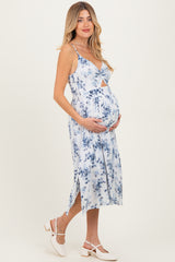 woman wearing a floral blue maternity dress and holding her baby bump