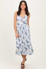 woman wearing a light blue floral midi dress with a front knot detail and spaghetti straps