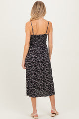 woman wearing a black floral maternity dress with adjustable spaghetti straps and a flowy mid-calf length