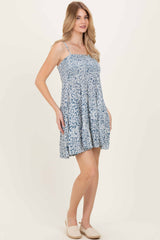 woman wearing a blue and white floral sundress with adjustable straps and a flowing fit