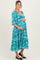 woman wearing a teal floral print maternity dress with a v-neckline and three-quarter sleeves, showing her baby bump