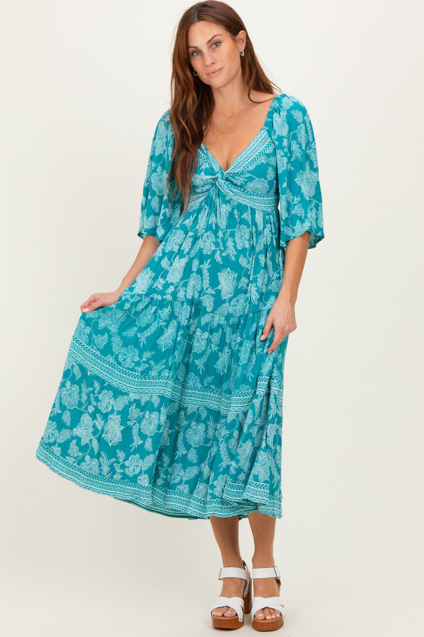 woman wearing a turquoise floral maxi dress with a tied bodice and short puff sleeves