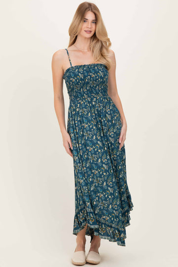 woman wearing a teal floral maxi dress with adjustable straps and a ruffled hem