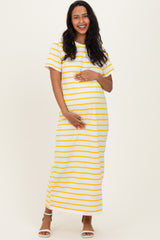 woman wearing a yellow and white striped maternity maxi dress and holding her baby bump