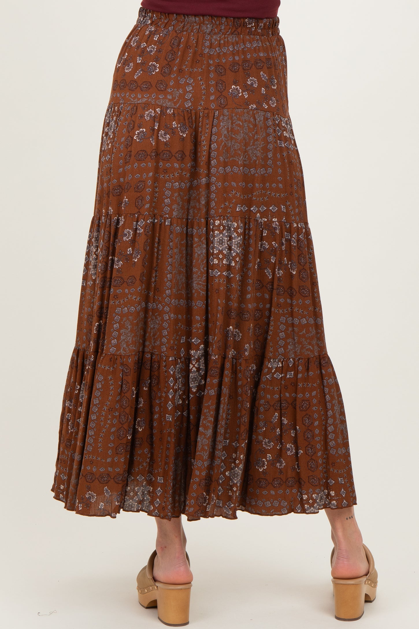 maternity wear brown tiered maxi skirt with floral print, model standing with back to camera