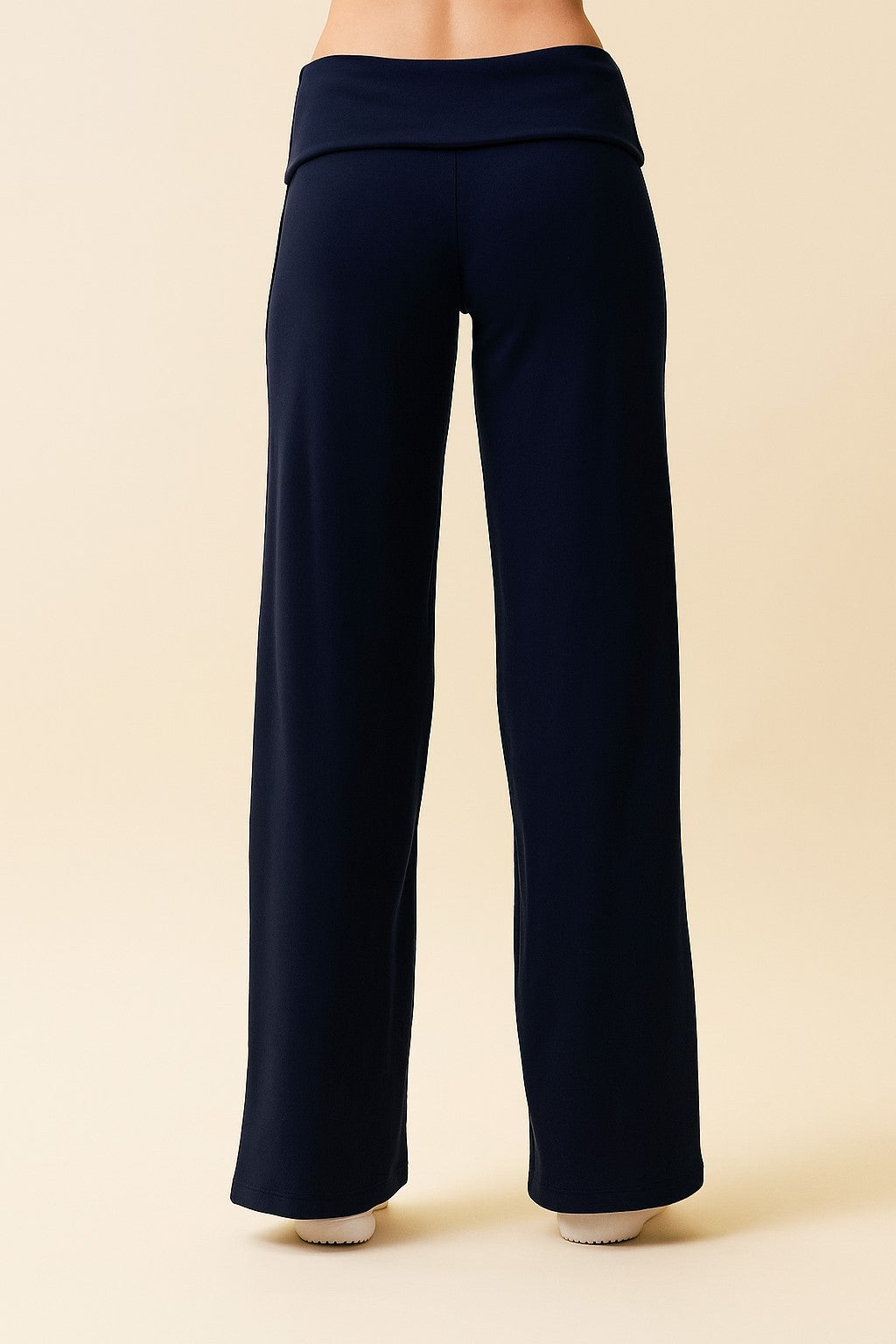 woman wearing navy blue wide-leg yoga pants with a fold-over waistband, viewed from the back
