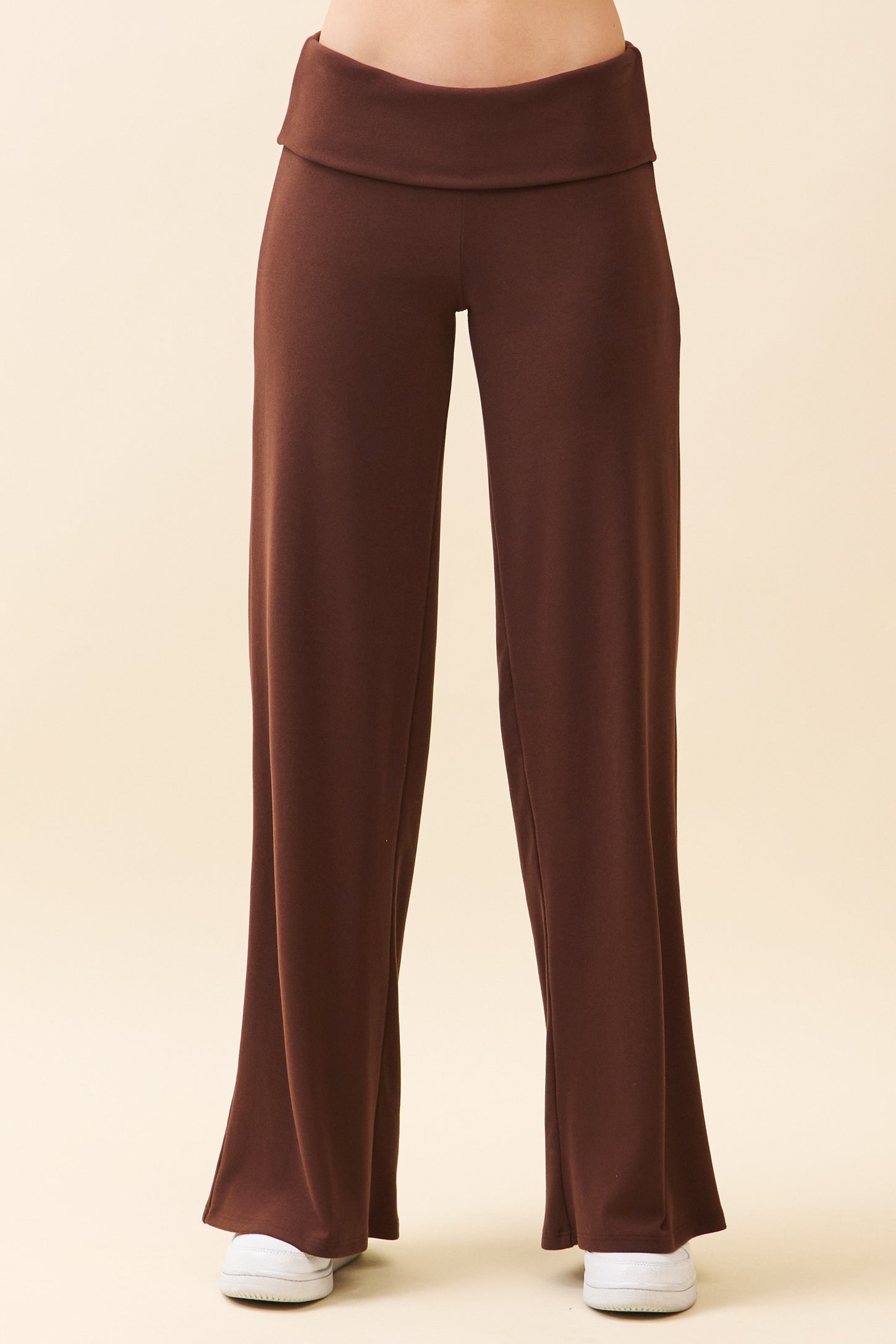 woman wearing brown flared lounge pants with a high waistband and side pockets