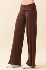 woman wearing brown wide-leg lounge pants with a high waistband and white sneakers
