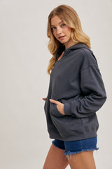 woman wearing a charcoal grey oversized hoodie with a front pocket and paired with denim shorts