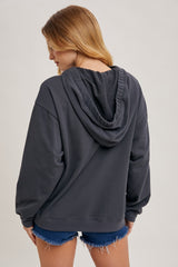 woman wearing a dark gray hooded sweatshirt with a relaxed fit and back view, paired with denim shorts