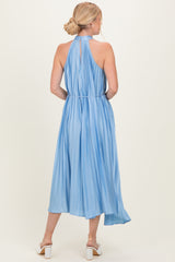 woman wearing a light blue pleated halter neck midi dress with a keyhole back and a flowy skirt