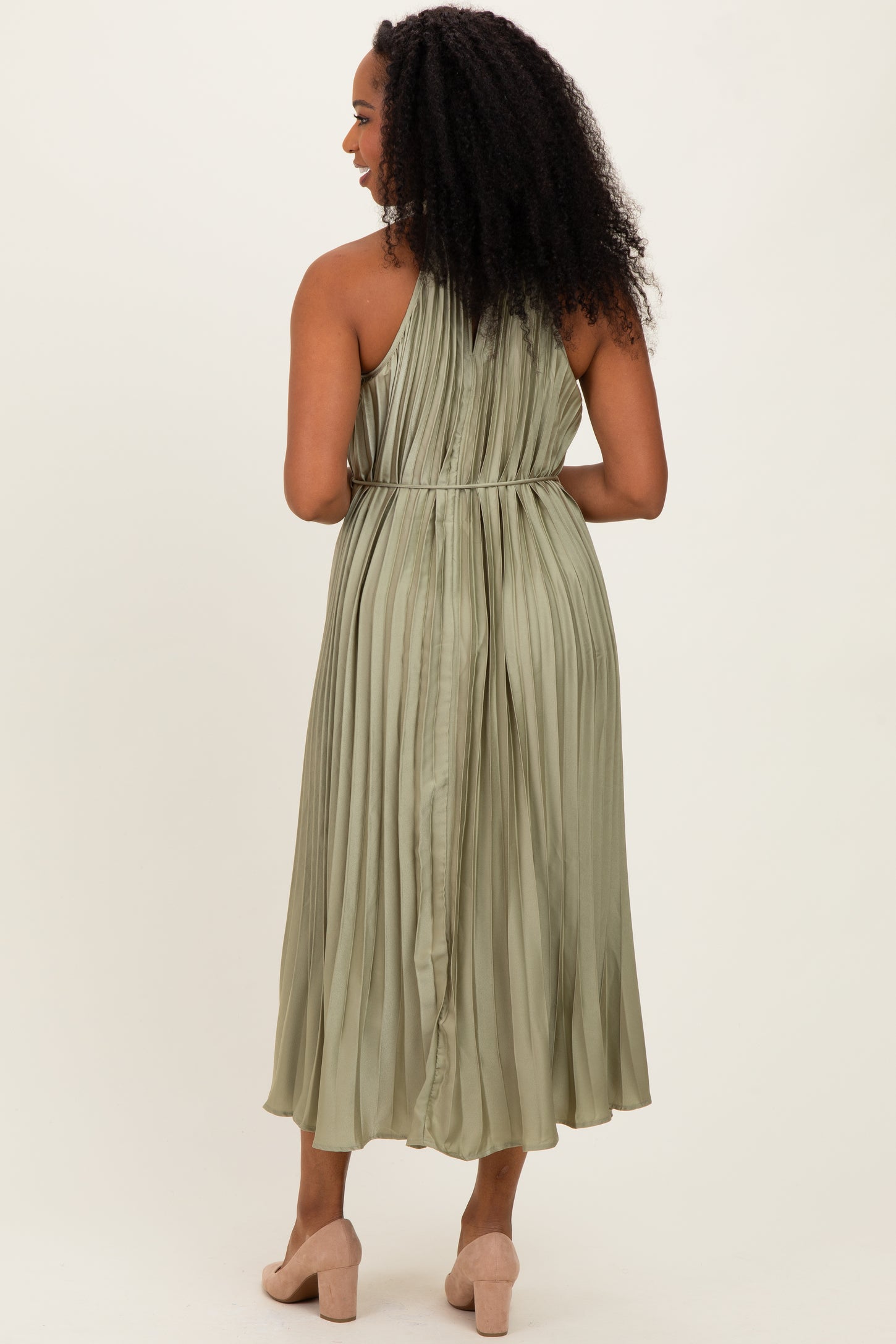 woman wearing a pleated olive green midi dress with a cinched waist, viewed from the back