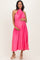 woman wearing a hot pink pleated maternity dress and holding her baby bump