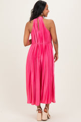 woman wearing a bright pink maternity pleated maxi dress, showing a keyhole back detail