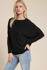 woman wearing a black oversized sweater with a relaxed fit and long sleeves, paired with light blue jeans