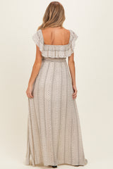 woman wearing a patterned beige maternity maxi dress with ruffled sleeves, viewed from the back