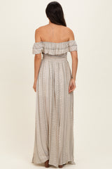 woman wearing a back view of a beige off-the-shoulder maxi dress with a smocked bodice and vertical stripes