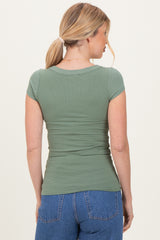 woman wearing a fitted olive green ribbed short sleeve top, showing the back view with light blue high-waisted jeans
