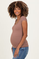 woman wearing a mauve short sleeve ribbed maternity top and showing her baby bump