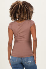 woman wearing a fitted brown maternity top with short sleeves, view from the back
