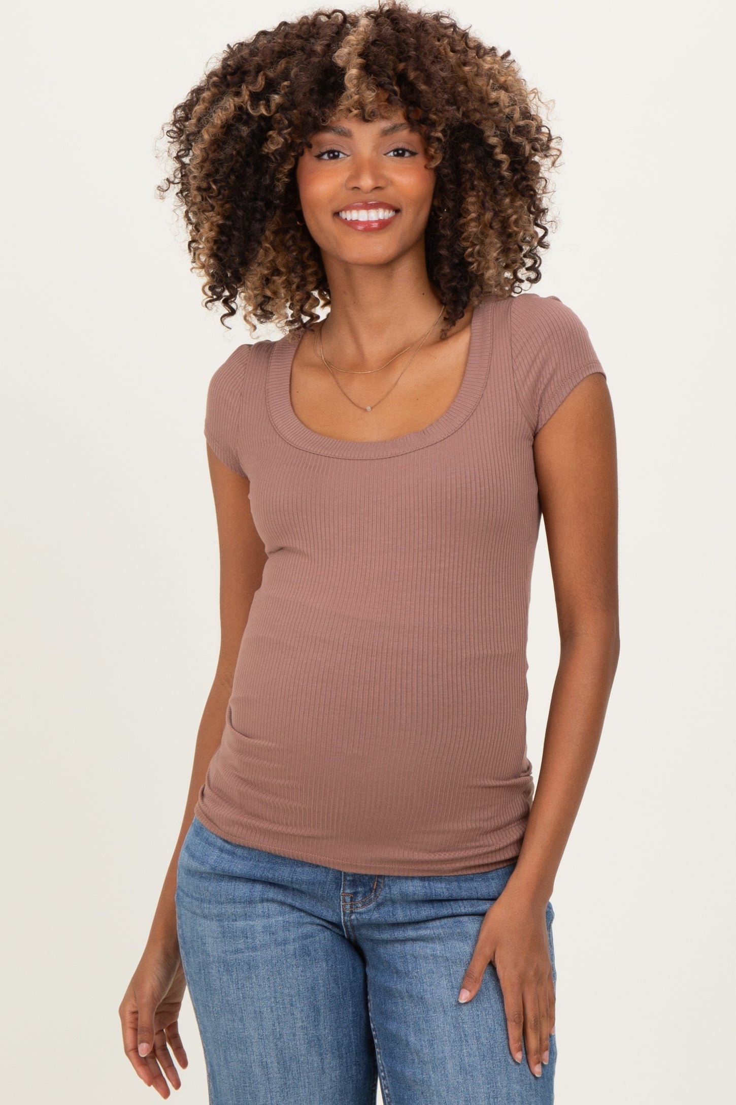 woman wearing a mauve ribbed maternity top with a scoop neckline and short sleeves, showing a baby bump