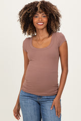 woman wearing a mauve ribbed maternity top with a scoop neckline and short sleeves, showing a baby bump