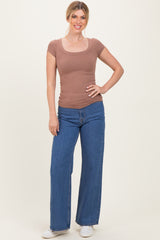 woman wearing a brown ribbed scoop neck fitted top and wide-leg blue jeans