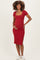 woman wearing a red ribbed maternity dress with a square neckline and side slits, holding her baby bump