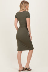 woman wearing a form-fitting olive green midi dress with short sleeves, seen from the back