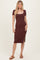 woman wearing a maroon fitted midi dress with short sleeves and a side slit